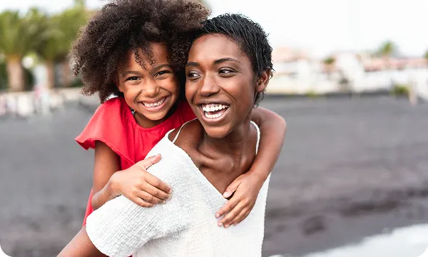 a woman giving a child a piggyback ride