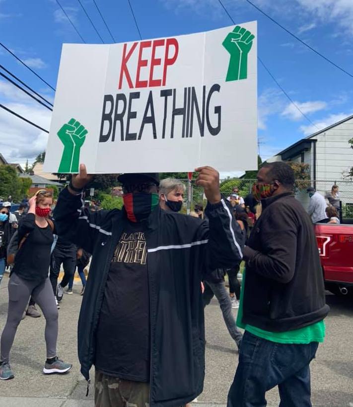 Anthony Austin holds "Keep Breathing" sign during anti-racism protest, June 7, 2020